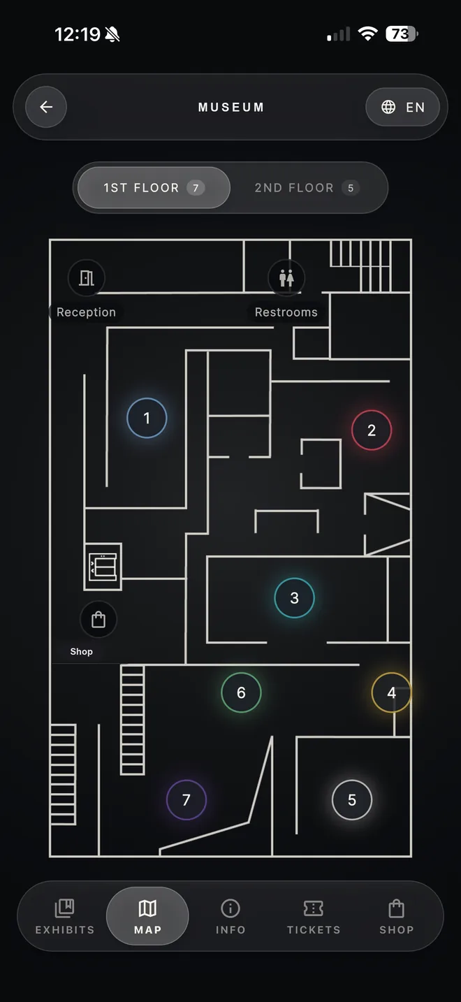 An interactive first floor plan with numbered exhibit pins, reception, restrooms and the shop.